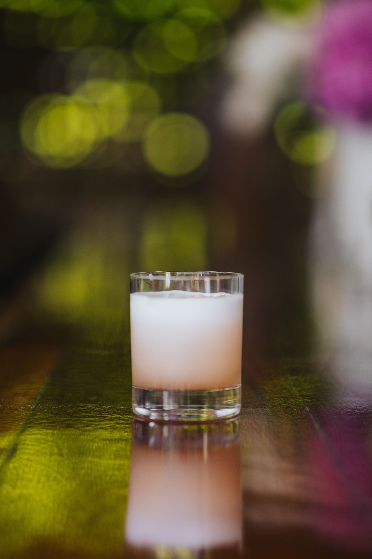 A pink rocks cocktail with foam